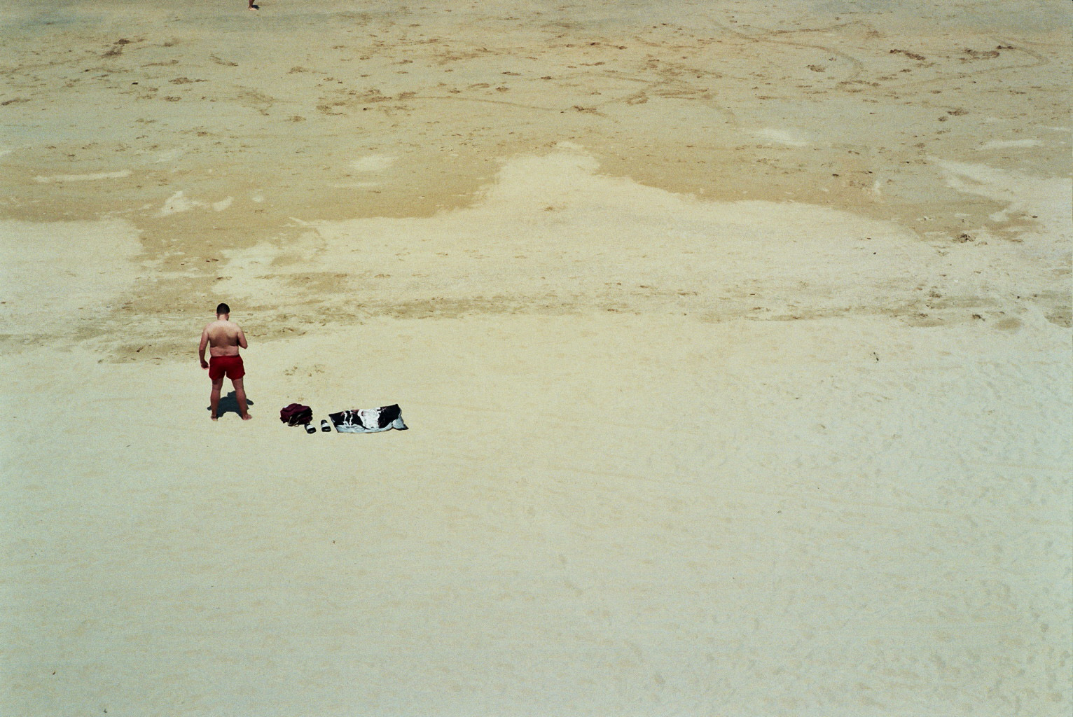 Man standing in the beach checking his mobile phone